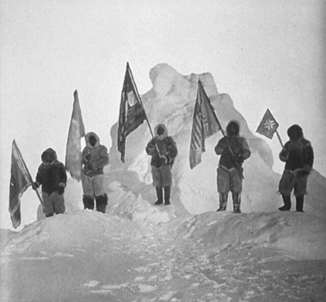 Kinder mit Flaggen auf Schneehügel in einer alten Schwarz-Weiß-Aufnahme.