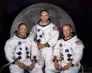 Astronauten im Raumanzug vor dem Mond, historische Raumfahrtaufnahme.